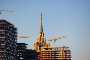 Fototapeta premium Construction of new skyscrapers in Moscow near river, Old high-rises on horizon in evening light