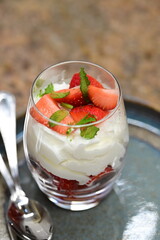 Close-up of traditional spring dessert with fresh strawberries and whipped cream in a glass. 