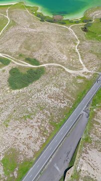 Scenic aerial drone image of a  island surrounded by white sand coastline. Chayei Island, Sevan, Armenia