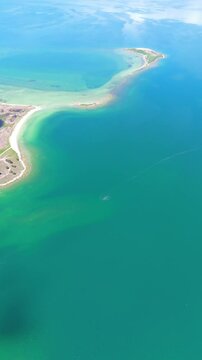 Scenic aerial drone image of a  island surrounded by white sand coastline. Chayei Island, Sevan, Armenia