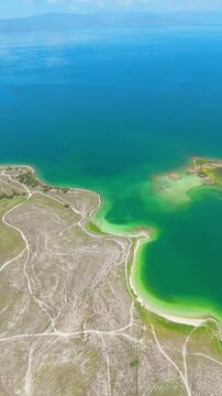 Scenic aerial drone image of a  island surrounded by white sand coastline. Chayei Island, Sevan, Armenia 