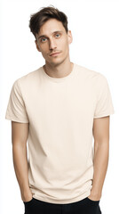 Young man with light brown hair wearing a plain beige t-shirt stands confidently with hands in pockets, showcasing a casual and relaxed demeanor in a neutral setting