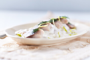 Herring in Cream Sauce on bright background. Copy space.	