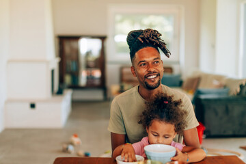 Father and daughter sharing a meal in their cozy home, embracing family time