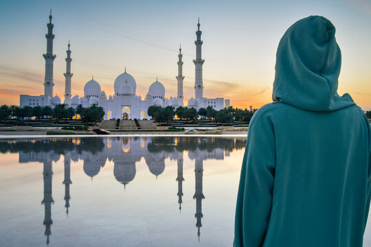 Close up Woman in traditional Arabic dress Abaya in Wahat Al Karama or Oasis of Dignity near Sheikh Zayed Grand Mosque in Abu Dhabi, showcasing cultural elegance,iconic Islamic architecture at sunset