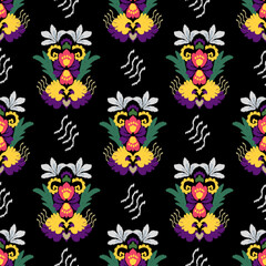 Yellow, green, and purple ikat seamless pattern with flowers and leaves on a black background. Design for elaborate borders, fashionable modern wallpaper, or textiles.