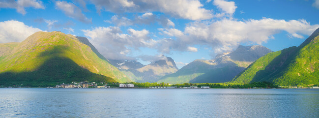 Norway. Nature in fjords. High mountains and reflections. Panoramic view. Clouds over the rocks. Vacation and travel in summer Norway. Background, wallpaper, postcards.