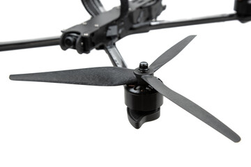 Close-up of a carbon fiber propeller and brushless motor on an FPV racing drone, isolated on white back