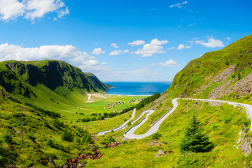 Panoramic view of the road and sea coast in Norway. Scandinavia. Nature. View of a mountain valley and a field with fresh grass. Beautiful summer view. Traveling by car.