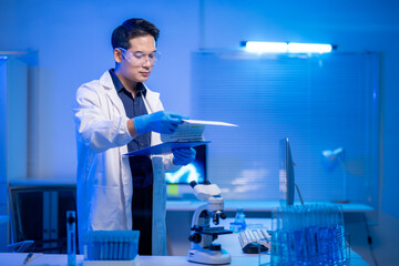 A man in a white lab coat is holding a piece of paper