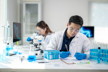 A man in a lab coat is writing on a clipboard