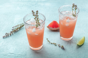 Salty Dog cocktail with fresh grapefruit juice, lime juice, and thyme, on a slate background