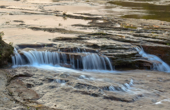 Scenic river flowing over rocky terrain, with small waterfalls, perfect for nature and landscapes in Meghalaya. - Powered by Adobe