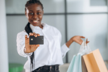 Credit card in hand, payment, shopping. Businesswoman in formal clothes is in the modern room