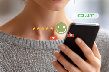 Woman rating customer satisfaction on mobile phone with five star review.