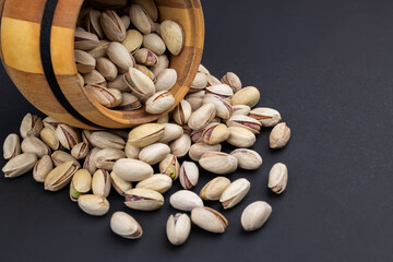 Pistachio in wood bowl on dark background