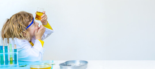 Laboratory examination of a child with test tubes, reagents and a microscope. Selective focus.