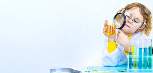 Laboratory examination of a child with test tubes, reagents and a microscope. Selective focus.