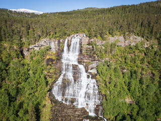 Majestic Tvindefossen waterfall, Norway, captured from a drone. Picturesque water cascades amidst...