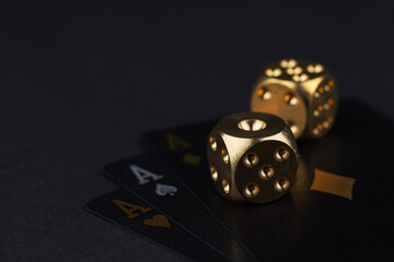 three aces cards and two dice on a dark background