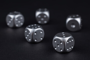 five silver dice view from above on black background