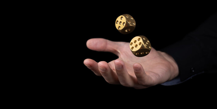 hand throwing two golden dice in the air on black background. Game with dice Gambling luck concept: bet, risk, have luck,
