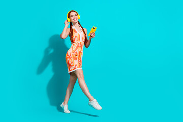 Full body portrait of lovely young woman enjoy music dance wear dress isolated on turquoise color...
