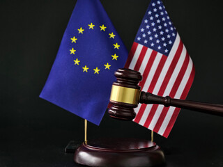 Gavel positioned between European Union and United States flags symbolizing international law and...