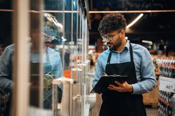 In formal wear. Male worker is in the grocery store