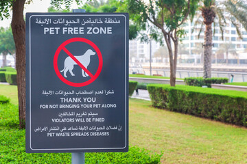 Park Sign Prohibiting Dog Walking in English and Arabic, Emphasizing Pet Regulations in Public Spaces.