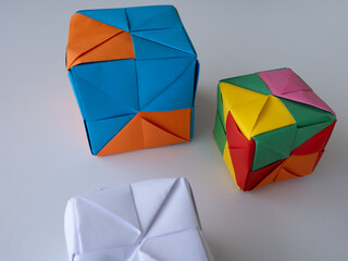 Bright modular origami cubes arranged on a white surface with minimal shadows.