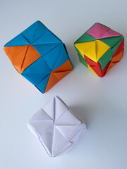 Bright modular origami cubes arranged on a white surface with minimal shadows.