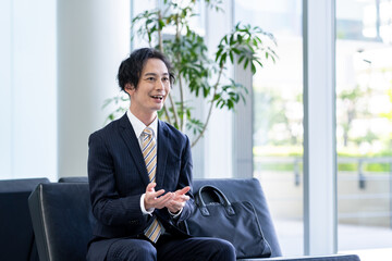 ロビーで営業するビジネスマン　撮影協力:スカパー東京メディアセンター