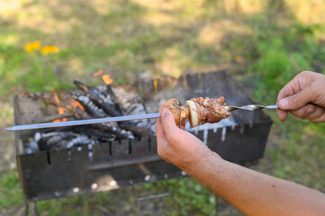 Male hands skillfully threading chunks of meat and mushrooms onto metal skewer. ingredients ready...