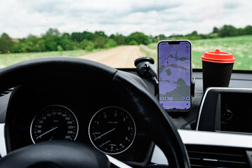 Driver using mobile phone with a GPS navigation map in car.