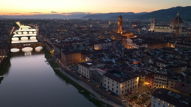 drone night view of Florence city with Arno river, Ponte Vecchio and Florence Cathedral, illuminated Florence evening view, tourism in Italian Tuscany
