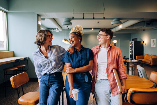 Group of young professionals smiling and enjoying each other's company in an office