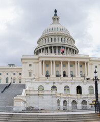 Wide-angle perspective captures the majestic architecture of the Capitol Building under a cloudy sky.