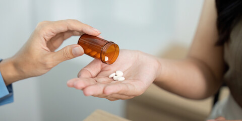 Patient Care. Healthcare professional providing medication from prescription bottle to patient.