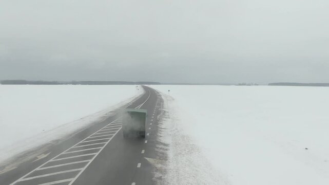 Aerial Drone Shot of Old Soviet Truck Driving Through Snowy Rural Landscape in Harsh Russian Winter