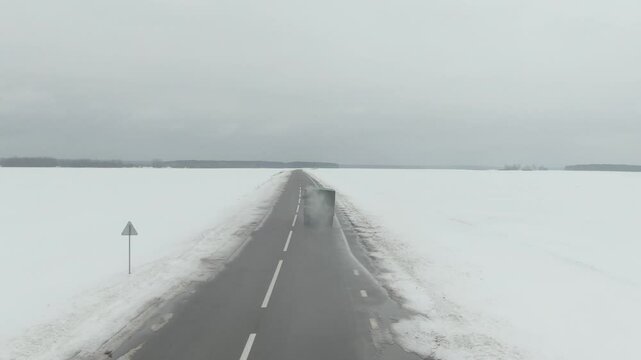 Aerial Drone Shot of Old Soviet Truck Driving Through Snowy Rural Landscape in Harsh Russian Winter
