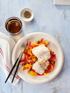 Cod Fillets Served on a Bed of Vibrant Bell Peppers and Garlic Showcasing a Colorful, Healthy Meal