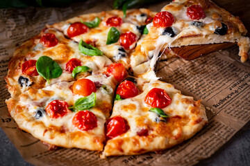 Homemade pizza for lunch. Italian cuisine: delicious pizza with tomatoes and mozzarella. Close-up