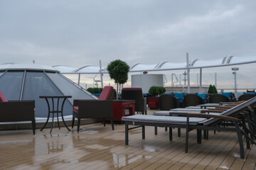 Outdoor whirlpool jacuzzi and private sun deck onboard modern luxury cruiseship cruise ship ocean liner with turquoise water, elegant rattan loungers and deck chairs for suite guests passengers