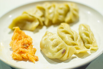 Momo , type of South Asian dumpling; native to Tibet, Nepal, Bhutan and Sikkim. It is similar to Chinese baozi and jiaozi, Mongolian buuz, Japanese gyoza and Korean mandu. Stock photograph.