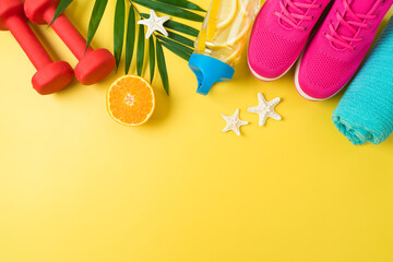 Summer fitness background with dumbbells, bottle of water, sport shoes and palm leaf. Top view with...