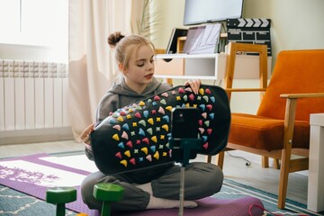 Teenager promoting acupressure mat in home fitness video