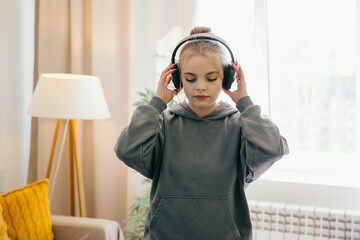 Teenage girl listening to music with headphones at home