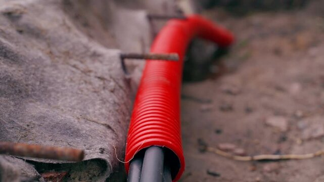 Red corrugated pipe for protecting electrical wiring, close-up