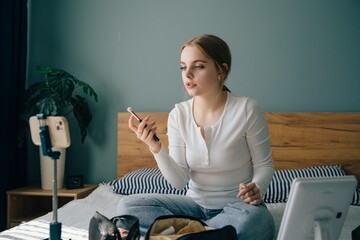 Influencer creating makeup tutorial video at home